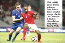  ?? CHANDRA SATWIKA/JAWA POS ?? PELAJARAN: Striker timnas Indonesia Boaz Solossa dalam kawalan pemain Islandia Orri Ómarsson di Stadion Utama Gelora Bung Karno, Jakarta (14/1).