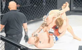  ??  ?? In the first of three pro MMA fights, Ryan "Killjoy" Potter, bottom, was able to break himself free from opponent Corey "The Drifter" Littler and eventually claim victory.