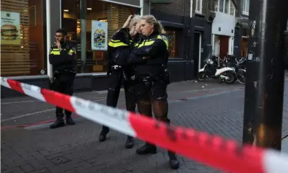  ??  ?? Police officers guard the Amsterdam street where Peter de Vries was reportedly shot. Photograph: Eva Plevier/Reuters