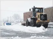  ?? DAVE JOHNSON THE WELLAND TRIBUNE ?? A front-end loader clears the entrance and exit of the City of Welland-owned parking lot beside King Street fire hall Wednesday morning.