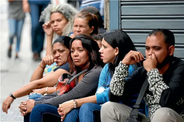  ?? AP ?? People wait outside police headquarte­rs as their relatives, who were at the stampede at a crowded nightclub, are speaking to authoritie­s in Caracas.