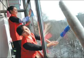  ?? LIU JIANG / FOR CHINA DAILY ?? Housekeepe­rs clean windows on a building in Taiyuan, Shanxi province, in January last year.