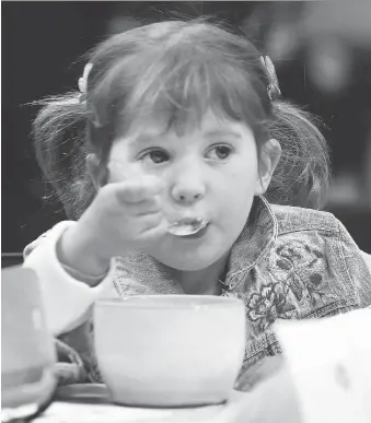  ?? DAN JANISSE/WINDSOR STAR ?? The Empty Bowls Windsor and Essex County fundraiser was held on Sunday at the Optimist Community Centre in Windsor. Julia MacDonald, 4, digs into a bowl of soup during the event.