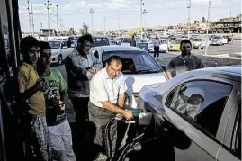  ?? Bryan Denton / New York Times ?? Long lines form at a gas station in Irbil, Iraq, on Wednesday as Islamic militants and government forces battled for control of the country’s largest oil refinery in Beiji, stoking fears about petroleum supplies.