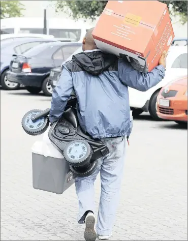  ?? PHOTO: LEON LESTRADE ?? Festive shoppers, like this man at N1 City in Goodwood shopping during the Black Friday Christmas season, may be paying the price now as the financial burden hits home.