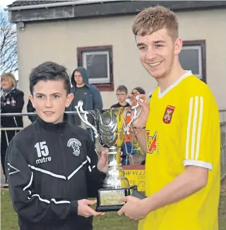  ??  ?? Lewis Finnie of Ferry Athletic U/19 is presented with the G Kerr/Maryfield Cup by Kristian Gibson. Ferry U/13 take on Carnoustie Panmure on Sunday.