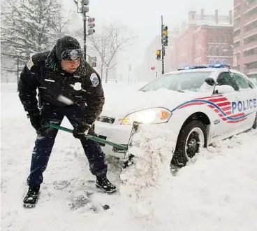  ?? AP ?? In Washington blieben auch Polizeiwäg­en aufgrund der Schneemass­en liegen