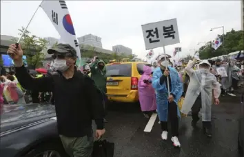  ?? Ahn Young-joon/Associated Press ?? Protesters march during a rally against the government Saturday in Seoul, South Korea.