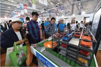 ??  ?? Visitors watch a model of an automatic parking lot at the 11th China-Northeast Asia Expo in Changchun, Jilin Province on September 1
