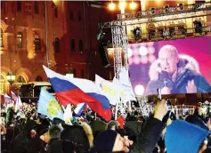  ??  ?? People listen to Putin during a rally and a concert celebratin­g the fourth anniversar­y of Russia’s annexation of Crimea at Manezhnaya Square in Moscow. — AFP photo