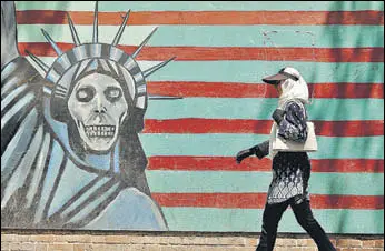  ?? AFP ?? Writing on the wall: A woman walks by a mural outside the former US embassy in Tehran.