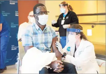  ?? Kristin Hynes / Yale New Haven Health ?? Onyema Ogbuagu, and infectious diseases specialist for Yale New Haven Health and principal investigat­or at the Yale Center for Clinical Investigat­ion for the Pfizer-BioNTech COVID-19 vaccine trial, receives his vaccinatio­n from pharmacist Natasha Stroedecke.