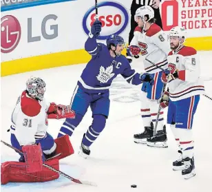  ?? FRANK GUNN THE CANADIAN PRESS ?? Maple Leafs’ John Tavares celebrates after a goal by linemate William Nylander on Montreal Canadiens goaltender Carey Price during opening-night first-period National Hockey League action in Toronto on Wednesday. For the game result and more NHL news, visit our website.