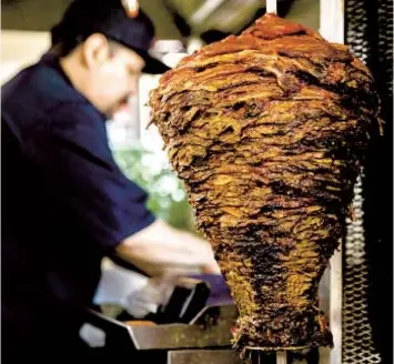  ?? ADRIANA HELDIZ U-T ?? Pork is grilled on a trompo at Al Pastor Town in National City.