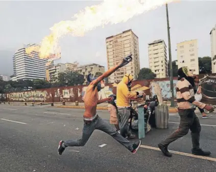  ?? FOTO: AFP ?? ►► Venezolano­s se enfrentan a la policía durante la protesta del miércoles en Caracas.