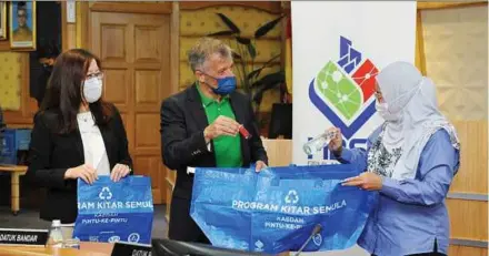  ?? ?? Nestle (Malaysia) Bhd chief executive officer Juan Aranols showing Subang Jaya mayor Noraini Roslan the blue recycling bags that will be provided to participan­ts of the kerbside recycling programme.