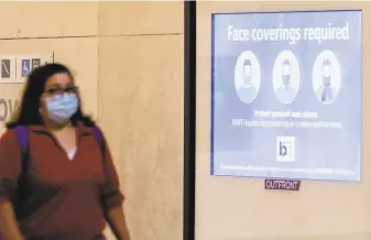  ?? Jessica Christian / The Chronicle ?? A sign reminds passengers to wear face masks at the Powell Street BART Station in San Francisco. Without good messaging, experts say, mask requiremen­ts like California’s may fail.