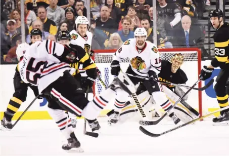  ?? | GETTY IMAGES ?? Bruins goalie TuukkaRask is ready to spring behind the Hawks’ Andrew Ladd (16) as defenseman Christian Ehrhoff (left) fires a shot.