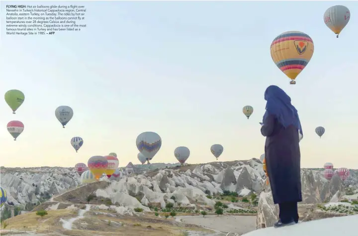  ?? FLYING HIGH: — AFP ?? Hot air balloons glide during a flight over Nevsehir in Turkey’s historical Cappadocia region, Central Anatolia, eastern Turkey, on Tuesday. The rides by hot air balloon start in the morning as the balloons cannot fly at temperatur­es over 28 degrees...