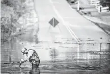  ?? Josie Norris / Associated Press ?? Dickson Public Works personnel check the flooding on Old Pond Lane following heavy rainfall Saturday in Dickson, Tenn. The flooding was blamed for at least eight deaths.