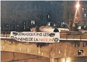  ??  ?? A large banner suspended from an overpass reads, “Unmask the enemies of the nation.”