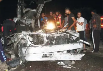  ?? (AP FOTO) ?? PALESTINIA­N rescue men inspect the wreckage of a vehicle following an Israeli air strike, at the main road in Rafah, Tuesday, July 15, 2014. The Israeli military says it has resumed air strikes on Gaza after Hamas militants violated a de-escalation...