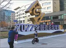  ?? TIAN YUHAO / CHINA NEWS SERVICE ?? A girl poses for a photo in front of the venue of Financial Street Forum in Beijing.