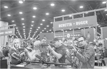  ?? Ty Wright / New York Times ?? Gun enthusiast­s shoot firearms at an exhibit last May during the National Rifle Associatio­n convention in Louisville, Ky. The gun-rights group lobbied against a rule that would have effectivel­y prevented most people with disabling mental illnesses from...