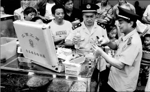  ?? LI JIANPING / FOR CHINA DAILY ?? Quality supervisio­n officers check samples of food at a market in Suichuan county, Jiangxi province, in July.