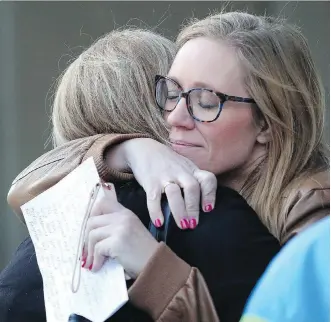  ?? LEAH HENNEL ?? Karine Ruiz hugs other members of the Taradale Community Associatio­n outside Calgary Courts Centre on Friday after the sentencing of Corey and Cody Manyshots in the brutal attack of a teenager in 2014.