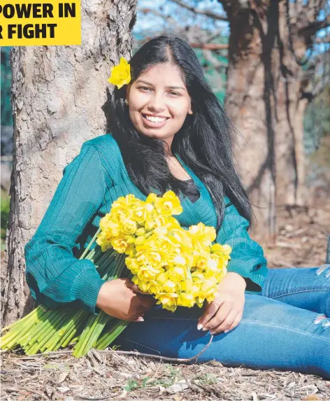  ?? Picture: ALISON WYND ?? BLOOMIN’ BUSY: Deakin student Snehal Midge loads up with flowers for Daffodil Day today.