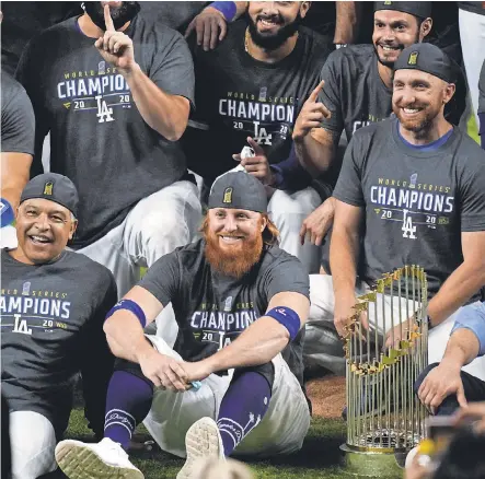  ?? ERIC GAY/ AP ?? Justin Turner, front right, celebrates the World Series championsh­ip with Dodgers manager Dave Roberts despite having tested positive for COVID- 19 earlier in the day Tuesday.