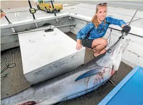  ?? SIMON O’CONNOR/STUFF ?? Amber McIntyre with the marlin destined for an official weigh in at the Clevedon Game Fishing Club in Auckland.