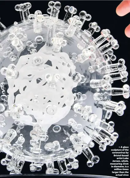  ??  ?? > A glass sculpture of the coronaviru­s by Bristol-based artist Luke Jerram, which, measuring 23cm in diameter, is a million times larger than the actual virus