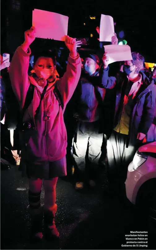  ?? AP ?? Manifestan­tes enarbolan folios en blanco en Pekín en protesta contra el Gobierno de Xi Jinping