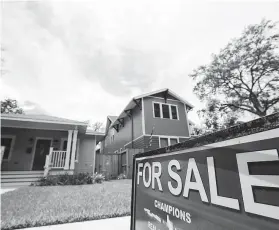  ?? Melissa Phillip / Staff photograph­er ?? A for sale sign is displayed outside a home on Ashland Street. Lower interest rates and higher demand are among factors driving up prices.