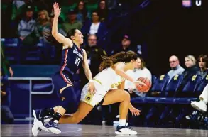  ?? Michael Caterina / Associated Press ?? UConn’s Nika Muhl (10) and Notre Dame’s Maddy Westbeld fight for possession during the first half on Sunday.