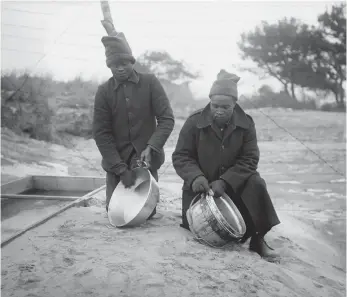  ??  ?? Photograph of African men cleaning ‘mess tins’ during the war.