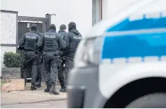  ??  ?? OUT IN FORCE: Policemen stand in front of a house in Erfurt, eastern Germany, where a raid took place in connection with the ban of the neo-Nazi group.