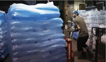  ?? MELISSA RENWICK/TORONTO STAR ?? Michael Aguilar loads ice into a freezer at the Iceman headquarte­rs on Adelaide St. W.