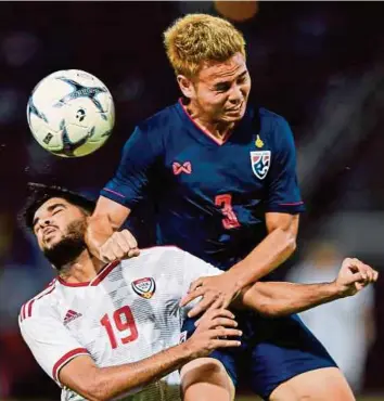  ?? AFP PIC ?? Thailand’s Theerathon Bunmathan (back) fights for the ball with United Arab Emirates’ Jassim Yaqoob Albalooshi in a World Cup qualifier in Bangkok on Tuesday. Thailand won 2-1.