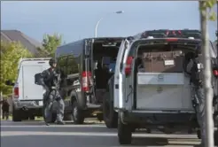  ?? CATHIE COWARD, THE HAMILTON SPECTATOR ?? Tactical officers suit up before heading into Bishop Tonnos Catholic Secondary School Wednesday morning. An 18-year-old man has been charged in relation to the incident.