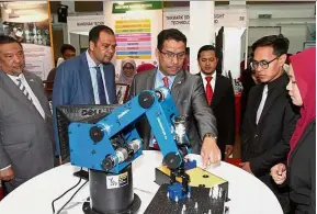  ??  ?? Azhar (foreground, third from left) speaking to MJII Robotic and Automation Year Two student Amirah Zalifah Ab Rahman (right) after the launch. With him are Mara Council members Datuk Ariss Samsudin and Datuk Johan Abd Aziz (left and second left).