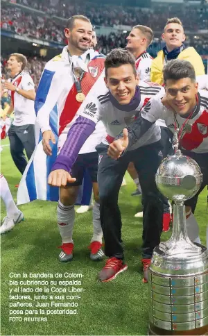  ?? FOTO REUTERS ?? Con la bandera de Colombia cubriendo su espalda y al lado de la Copa Libertador­es, junto a sus compañeros, Juan Fernando posa para la posteridad.