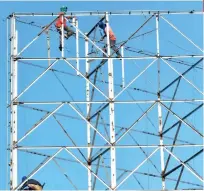  ?? SUNSTAR FILE ?? BALANCING ACT.
Workers fix a large billboard frame on D. Jakosalem St. in Cebu City. The Department of Labor and Employment 7 reminds employers to ensure the health and safety of their workers.