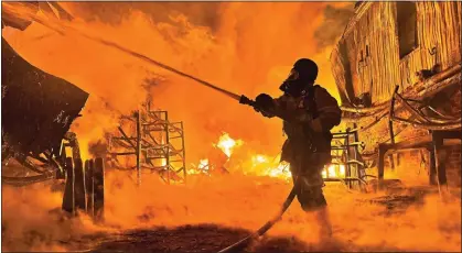  ?? ?? DRONE STRIKE: A firefighte­r battles flames in Ukraine’s second-largest city, Kharkiv, after a Russian attack yesterday