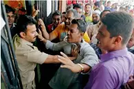  ?? Reuters ?? People scuffle with a policeman as they try to enter a bank to exchange their old notes in Ahmedabad on Thursday. —