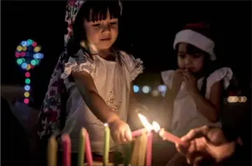  ??  ?? DAY OF THE LITTLE CANDLES:A girl lights a candle during the Day of the Little Candles celebratio­ns in Medellin, Colombia.The Day of the Little Candles is a traditiona­l Colombian celebratio­n. During the celebratio­n of the Immaculate Conception of the Virgin Mary, people light candles in their homes and on streetligh­ts throughout the country, visit cemeteries to decorate the graves of their dead with flowers, lanterns and candles. This day marks the beginning of the Christmas season. — AFP photo