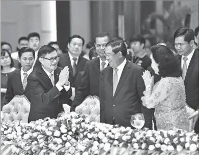  ?? PROVIDED TO CHINA DAILY ?? Dong Wenbiao (left), chairman of China Minsheng Investment Group, meets Cambodian Premier Hun Sen (middle) and his wife during the first-ever Cambodia-China Business and Financial Developmen­t Forum held in Phnom Penh on Dec 1.
