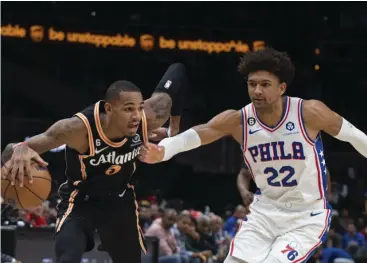  ?? AP/HAKIM WRIGHT SR▪ PHOTO ?? ATLANTA Hawks’ Dejounte Murray drives past Philadelph­ia 76ers’ Matisse Thybulle during the first half of an NBA basketball game Thursday, Nov▪ 10, 2022, in Atlanta▪